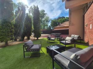 a group of chairs and tables on a lawn at Hotel Korona in Siófok