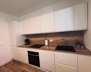 a kitchen with white cabinets and a sink at Bassano Sweet Home in Bassano del Grappa