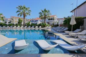a swimming pool with lounge chairs and a hotel at Hotel Tropical in Hanioti