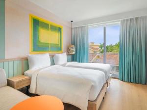 a hotel room with two beds and a window at ibis Styles Goa Vagator - An Accor Brand in Vagator +49 photos