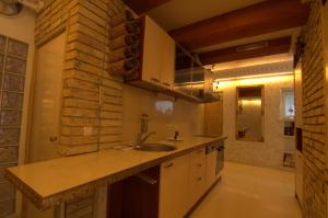 cocina con fregadero y pared de ladrillo en Vilnius Luxury Apartment 3 en Vilna