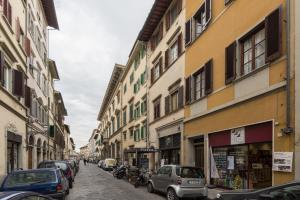 una strada di città con auto parcheggiate sui lati degli edifici di Roommo Studio San Gallo a Firenze