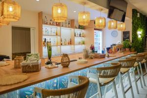 a restaurant with a long bar with chairs at Hotel Tropical in Hanioti