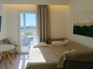 a bedroom with a bed and a table and a window at Eva Ivoni apartments in Amoudara Herakliou +85 photos