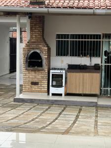 a kitchen with a stove and a brick oven at A 3,3 km do Parque do Povo in Campina Grande