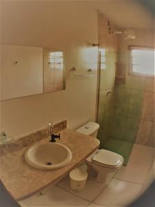 a bathroom with a sink and a toilet and a shower at Sossego de Jaua in Camaçari