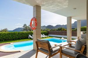 a villa with a swimming pool and two chairs at Villa Ca'n Tugores by Rentallorca in Colonia de Sant Pere