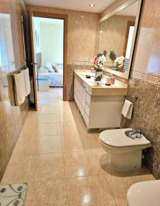 a bathroom with a toilet and a sink and a mirror at House TAMARIT PLAYA in Tarragona +31 photos