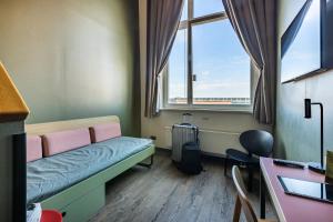 a small room with a bed and a window at MEININGER Hotel Berlin Mitte in Berlin +57 photos