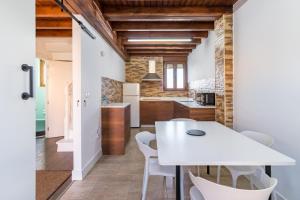 a kitchen and dining room with a white table and chairs at El Rincón de Denver in Suances