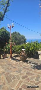 a street light next to a stone patio with the ocean at SPITIKARIOTIKO My Ikarian home in Raches +28 photos