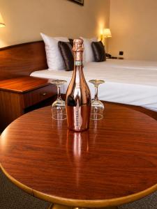 a bottle of wine on a table with two glasses at Hotel Orbita in Varna City