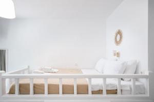 a white bedroom with a bed with white pillows at White island rooms in Panteli