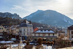 a town with snow covered buildings and a mountain at Central Parc T2 Pour 4 Pers in Briançon