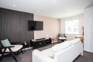 a living room with a white couch and a flat screen tv at Arkless Grove FREE Parking WiFi in Black Hill