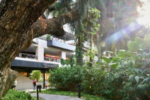 a person walking in front of a building at Mandarin Oriental Makati, Manila in Manila