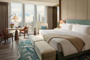 a hotel room with a large bed and a table at Mandarin Oriental Makati, Manila in Manila +37 photos