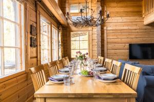 a dining room with a long wooden table and chairs at Koivulankaari 17 in Tahkovuori +21 photos
