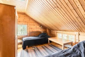 a bedroom with a bed and a table in a log cabin at Koivulankaari 17 in Tahkovuori
