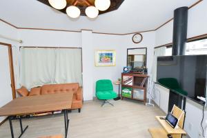 a living room with a couch and a table and a tv at Re-home in Izunokuni