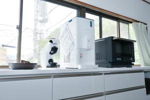 a counter with two microwaves and a microwave on it at Re-home in Izunokuni