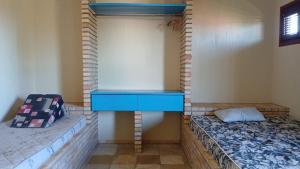 a room with a blue table and two beds at Flat Casa Taiba 2001 in Taíba