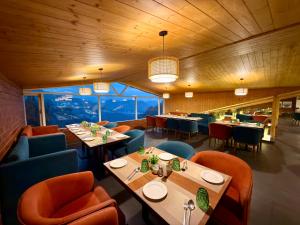 a restaurant with wooden ceilings and tables and chairs at ARNISA Kasauli - A Boutique Hotel in Kasauli