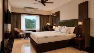 a bedroom with a bed and a desk and a window at Hotel Mulki International in Mūlki