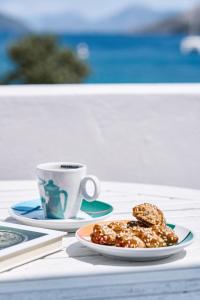 a plate of donuts and a cup of coffee on a table at White island rooms in Panteli