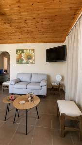 a living room with a couch and a table at Olive holiday home in Laganas