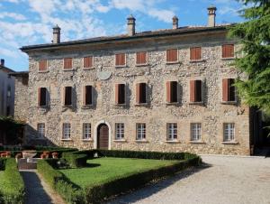an old stone building with a garden in front of it at Palazzo Brighenti in Pozzolengo