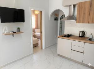 a kitchen with white cabinets and a tv on the wall at Electra Gaios Apartment in Gaios