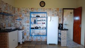 a refrigerator in a kitchen with a wall covered in magnets at Flat Casa Taiba 2001 in Taíba