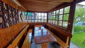 a wooden bench in a room with windows at Вила Багрянови in Dospat