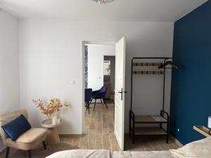 a room with a bedroom with a bed and a chair at L'Opaline - Bord de Seine près de Giverny in Vernon
