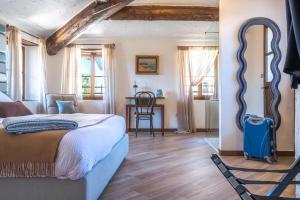 a bedroom with a bed and a table with a chair at Palazzo Brighenti in Pozzolengo