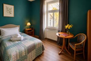 a bedroom with a bed and a table and a window at Parkhotel Waldschlösschen in Annaberg-Buchholz +136 photos