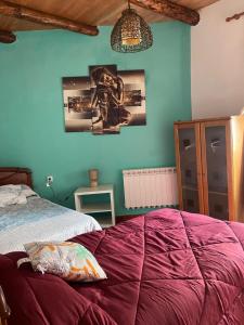 a bedroom with a bed and a blue wall at Casa El Filali in Villaminaya