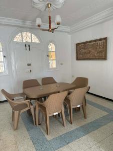 a dining room with a wooden table and chairs at villa Flamingo in Sousse +14 photos