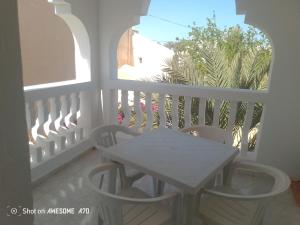 a white balcony with a table and two chairs at villa Flori Midoun in Djerba