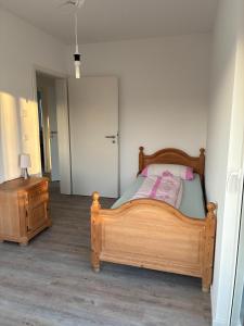 a bedroom with a wooden bed and a night stand at Hedwig und Anna in Zapfendorf