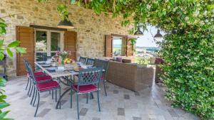 a dining table and chairs on a patio at CASALE DEI GELSOMINI 8, Emma Villas in Todi