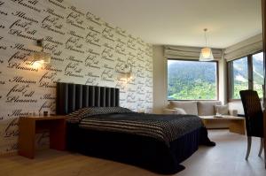 a bedroom with a wall covered in writing on the wall at Forest Suites Boutique Hotel in Megalo Chorio
