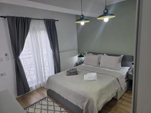 a white bedroom with a large bed with a window at Apartament My Room in Curtea de Argeş