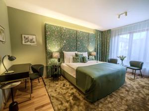 a bedroom with a large bed and a desk at Platán Villa - Platán Tata in Tata