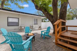 a group of blue chairs sitting around a tree at La Casita St Pete in St. Petersburg