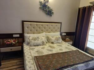 a bedroom with a large bed with pillows at Ashiana in Patiāla