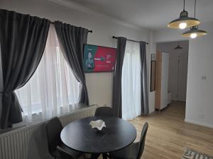 a dining room with a black table and chairs at Apartament My Room in Curtea de Argeş