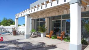 a white pergola with chairs and tables on a patio at Holiday Inn Express Guaymas by IHG in Guaymas