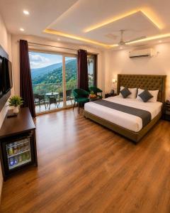 a bedroom with a large bed and a large window at Hotel The Girnaar Near Valley View Dharampur Kasauli Road in Dharampur